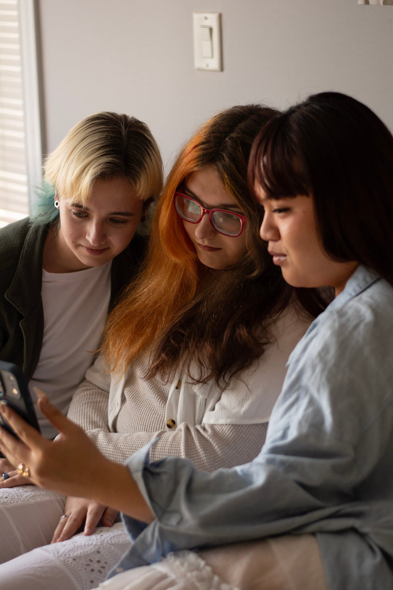 Three friends gathered around a phone